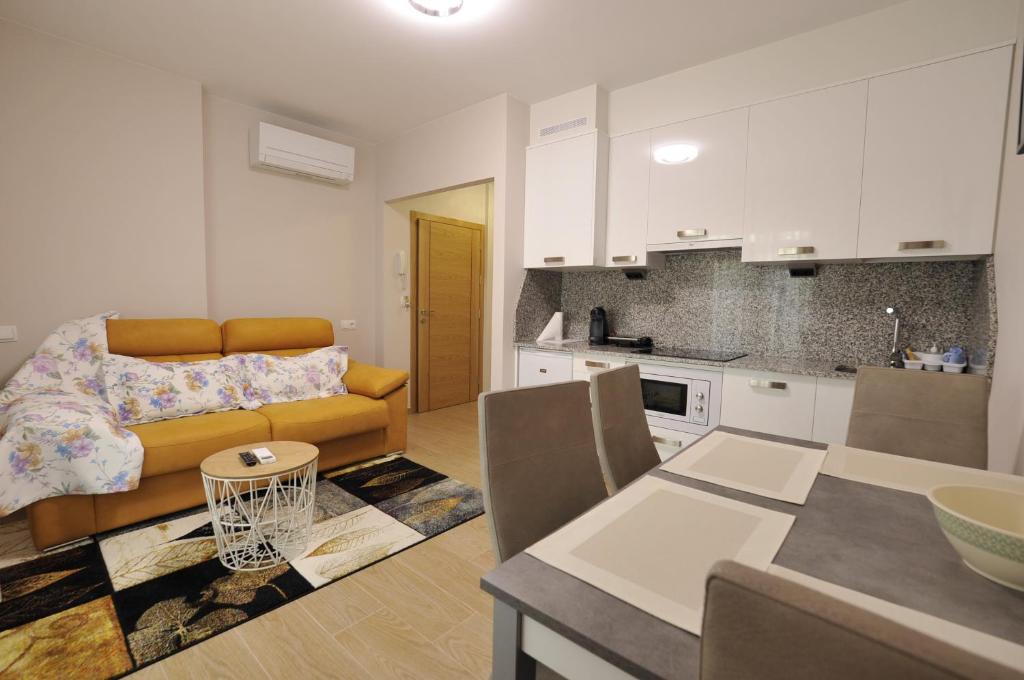 cocina y sala de estar con sofá y mesa en Apartamentos Playa Compostela, en Vilagarcía de Arousa