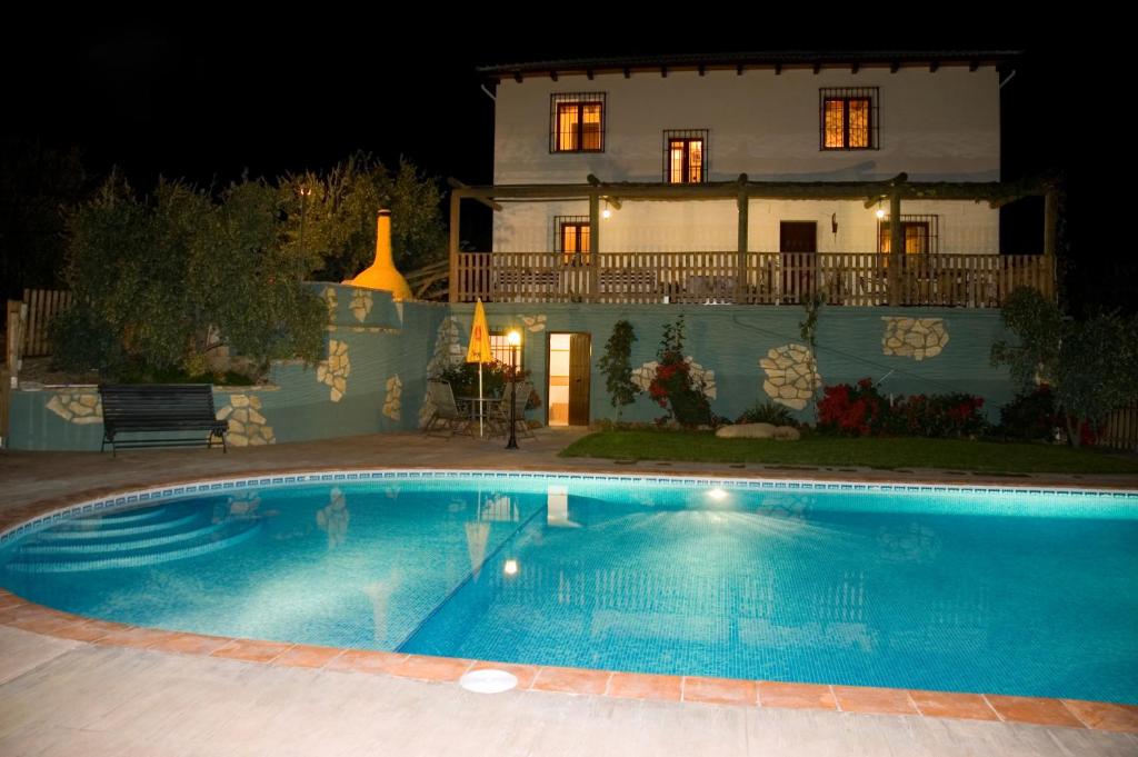 una piscina frente a una casa por la noche en Casa Rural El Tejar Viejo, en Carcabuey