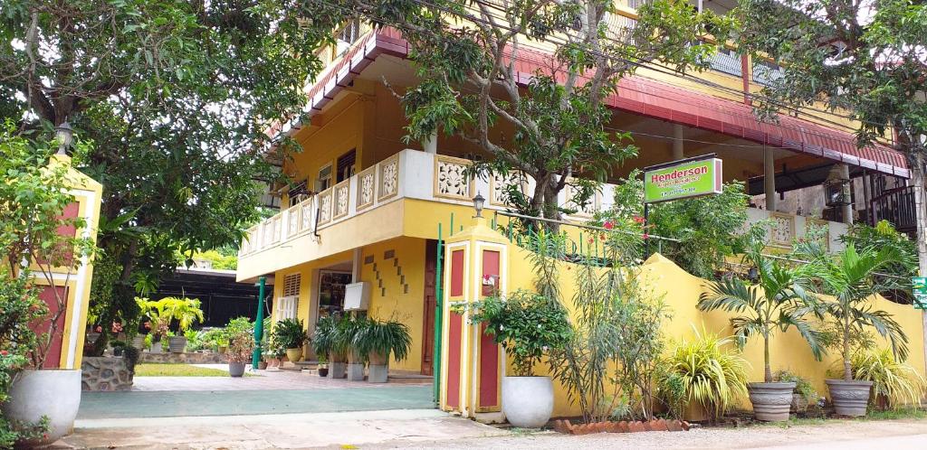 un edificio giallo con piante di fronte di Henderson Airport Residence a Negombo