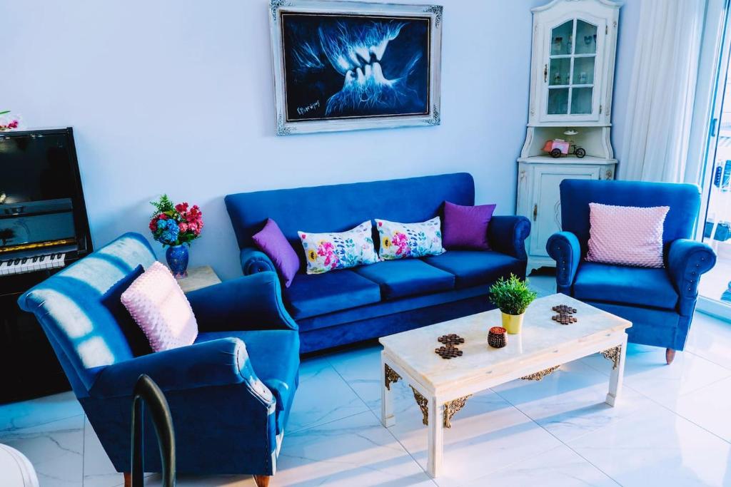 a living room with two blue couches and a table at Vintage Art home on the sea in Thessaloniki