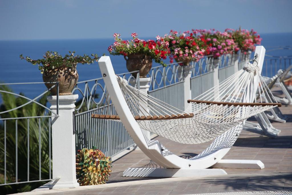 a white hammock sitting on a balcony with flowers at Residence Porto Ulisse in Parghelia