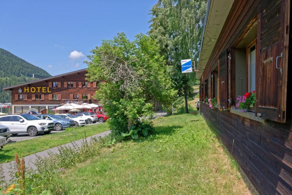 un edificio con un árbol al lado de un aparcamiento en Motel Bivouac de Napoléon, en Bourg-Saint-Pierre