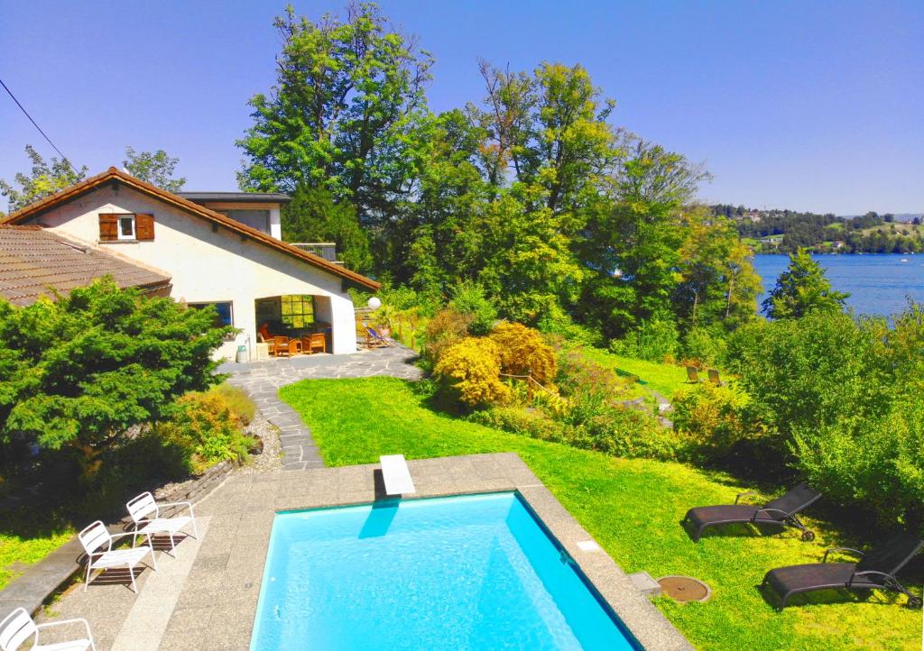 a swimming pool in a yard next to a house at Lake Villa Lotus in Luzern
