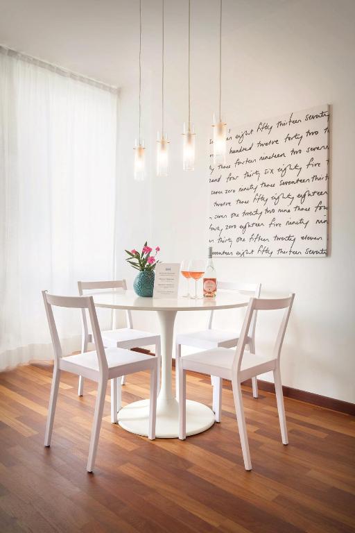 a white dining room with a white table and chairs at LA CHIARETTO SUITE in Bardolino