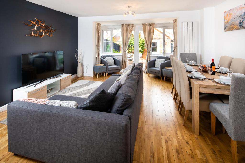 a living room with a couch and a dining room at Brightleap Apartments - Modern and Spacious Home From Home 1 mile from M1 - Netflix, Prime Video, PS5 - Sleeps 11 in Milton Keynes