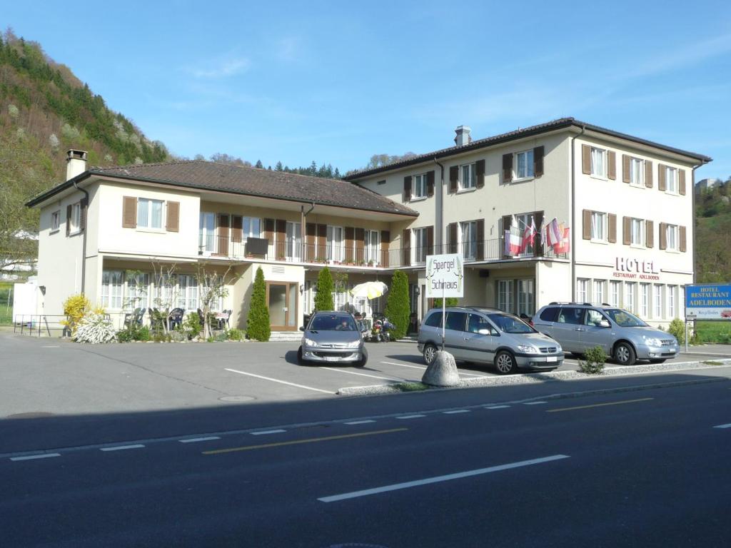 a large building with cars parked in a parking lot at Hotel Adelboden in Wikon