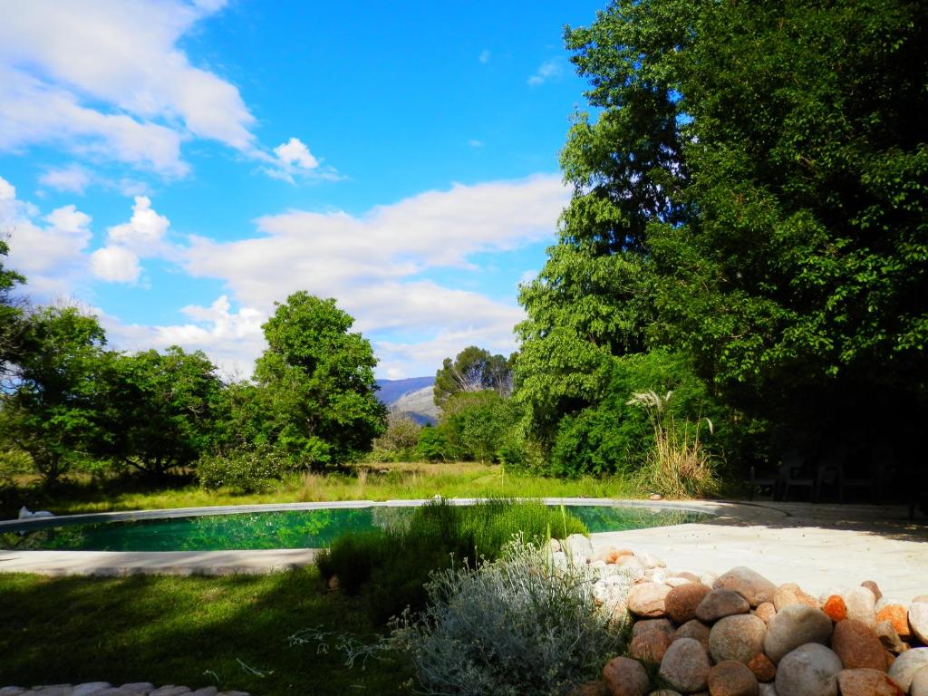 a swimming pool in the middle of a yard with trees at Manantial Hostería & Cabañas in Nono