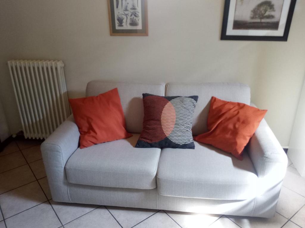 un divano bianco con quattro cuscini sopra di Appartamento Luisa a Parma