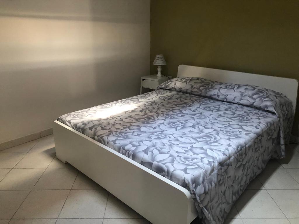 1 dormitorio con 1 cama con edredón blanco en Bilocale in centro con giardino en Tagliacozzo