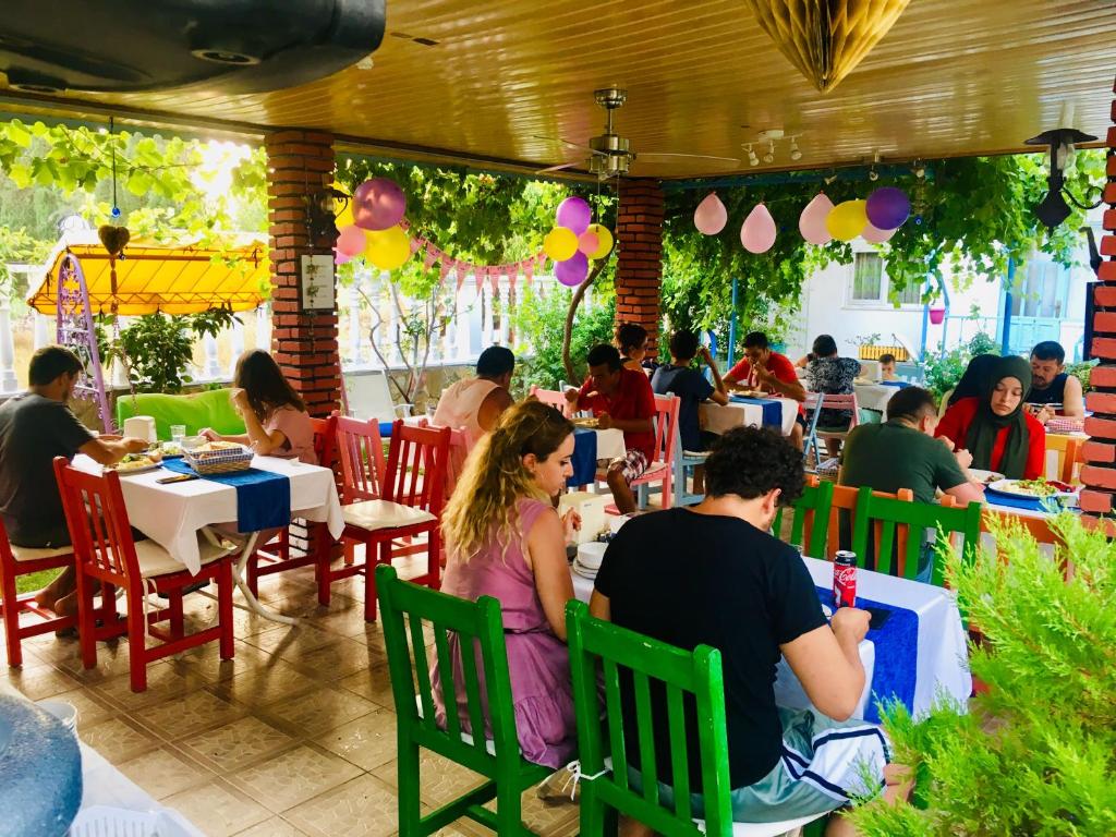 un grupo de personas sentadas en mesas en un restaurante en Side Erenler Hotel en Side