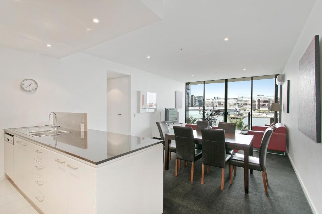 a kitchen and dining room with a table and chairs at Docklands Private Collection - NEWQUAY in Melbourne