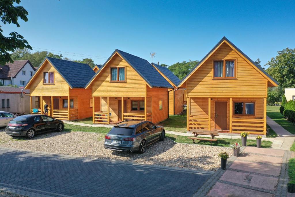 a row of wooden homes parked in a parking lot at Słoneczne Domki Pustkowo, 1 minuta do plaży, in Pustkowo