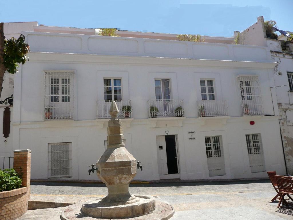 une maison blanche avec une fontaine devant elle dans l'établissement Benali Guest House, à Tarifa