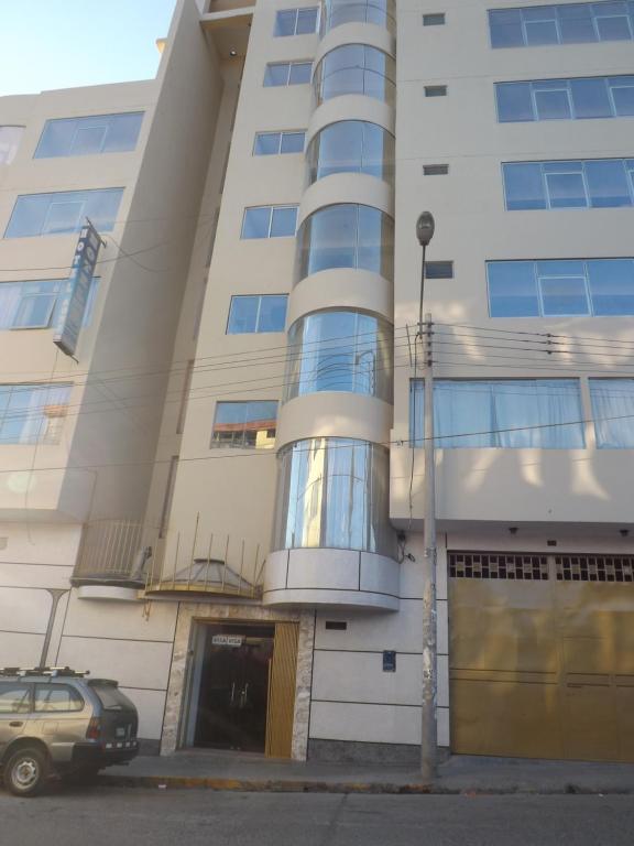 a building with a car parked in front of it at Hotel Wanka Palace in Huancayo