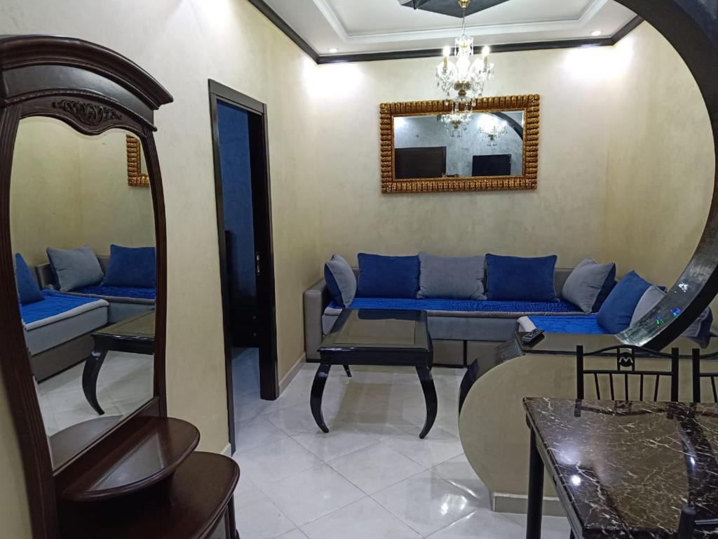 a living room with blue couches and a mirror at Apartement 3 residence oulad touimi in Martil