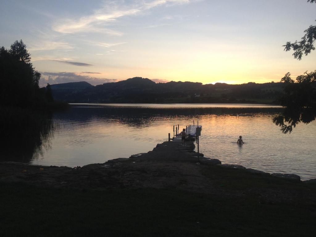 a person swimming in a lake at sunset at Fewo in Tiefenberg/ Allgäu in Ofterschwang