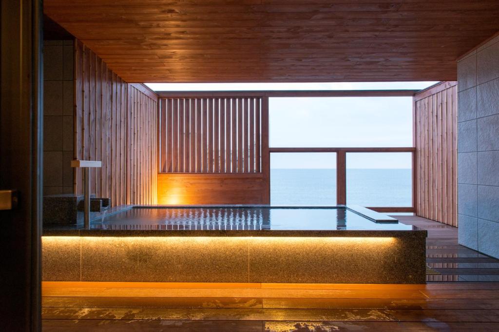 bañera de hidromasaje en una habitación con vistas al océano en Umiusagi, en Higashiizu