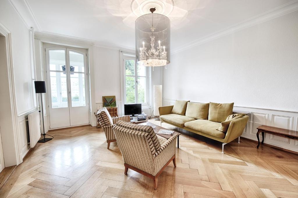 a living room with a couch and chairs at Am Pavillon, Bed&Kitchen in Bern