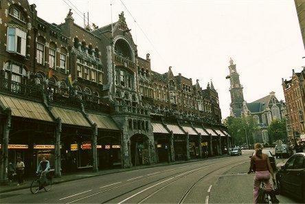 uma rua da cidade com pessoas a andar de bicicleta e edifícios em Hotel de Westertoren em Amsterdã