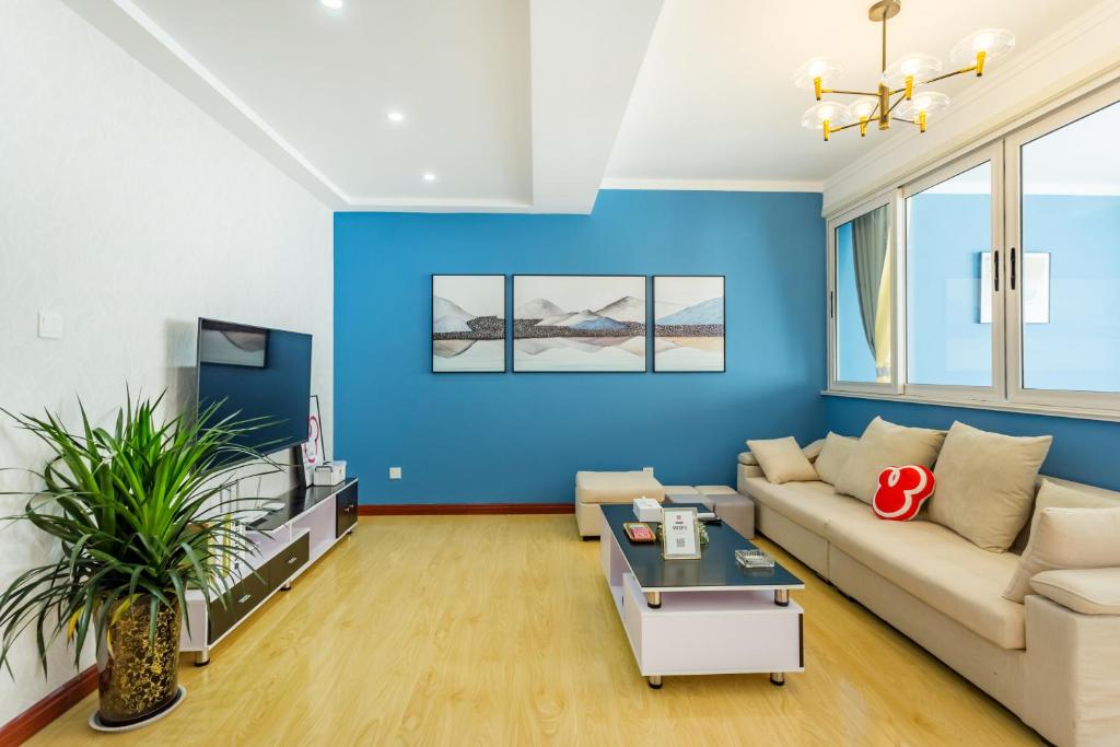 a living room with blue walls and a couch at 【locals】Taian Taishan District Baolongcity Square in Tai'an