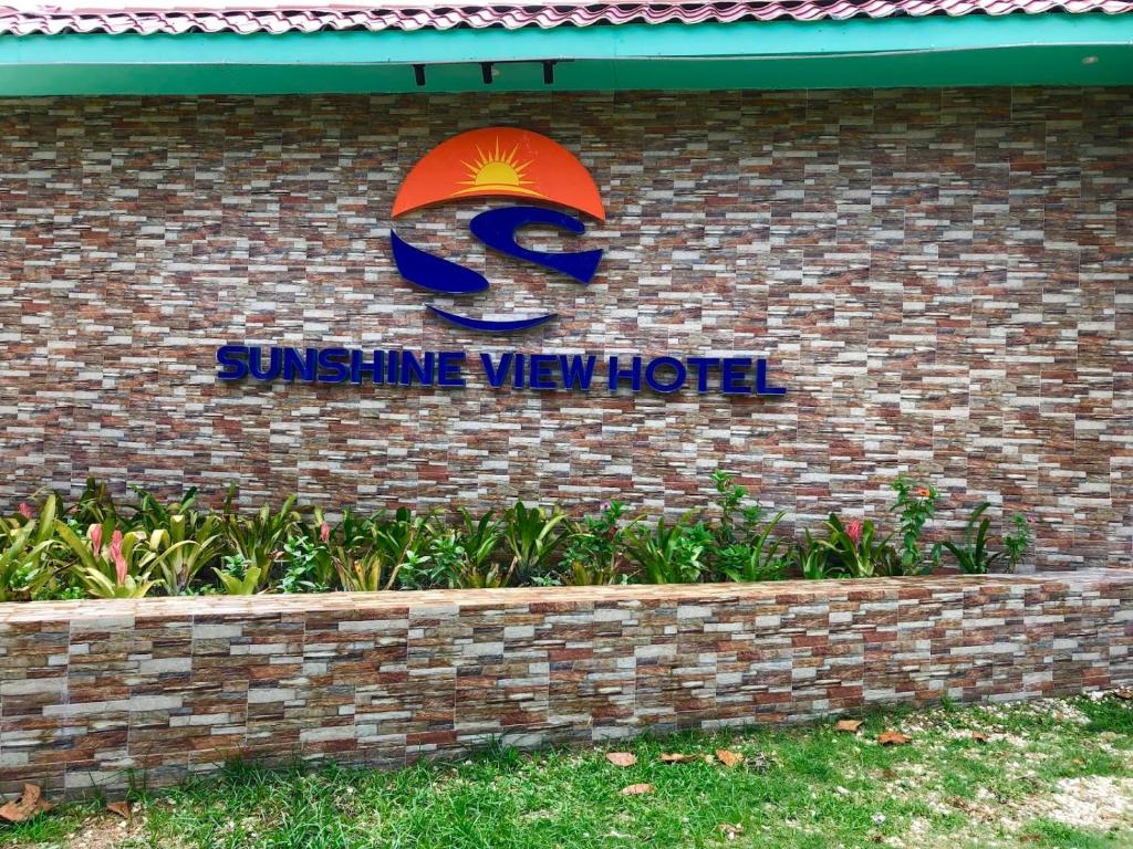 a sign for a sigma way hotel on a brick wall at Sunshine View Hotel and Restaurant in Corozal