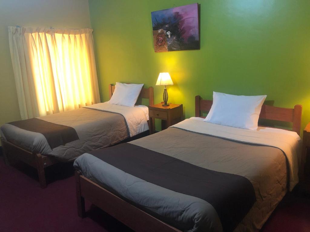 Habitación de hotel con 2 camas y ventana en Hospedaje Turistico Recoleta, en Cusco