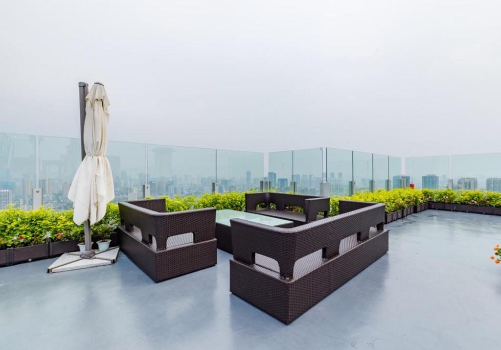 un patio con 2 sofás y una sombrilla en un edificio en Chengdu Chenghua·Simaqiao Alley, en Chengdú
