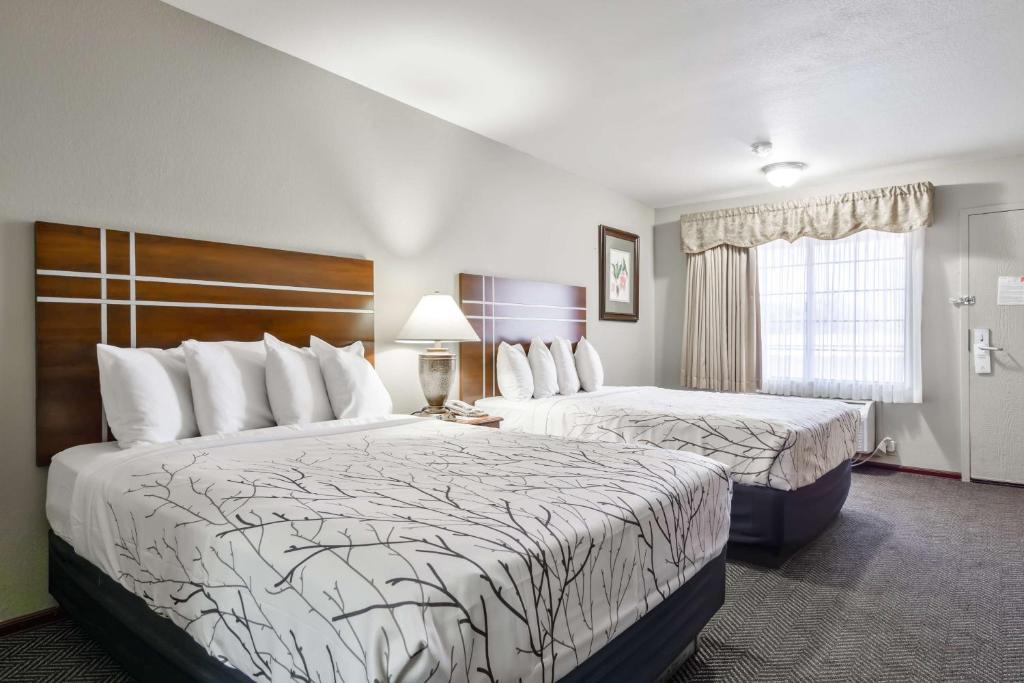 een hotelkamer met twee bedden en een raam bij Rancho San Diego Inn & Suites in El Cajon