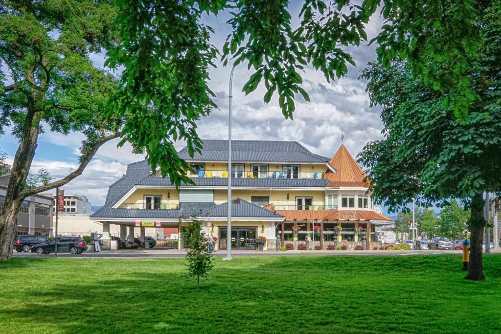 a large building with a green lawn in front of it at Prestige Beach House, WorldHotels Crafted in Kelowna
