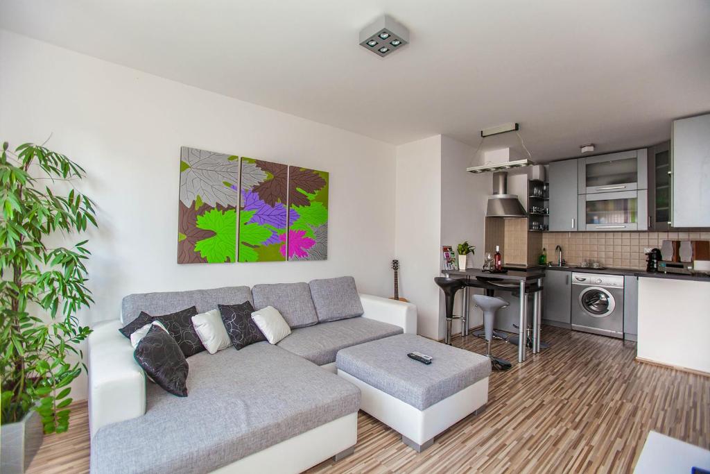 a living room with a couch and a kitchen at Mentha Apartments Deluxe - MAD in Budapest