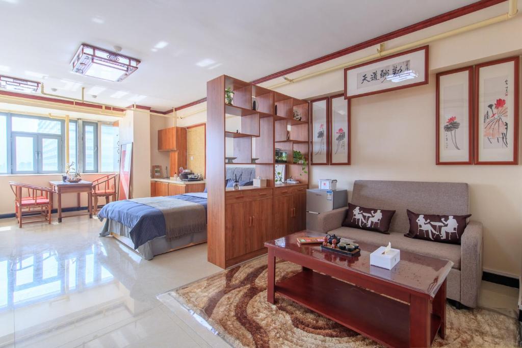een kamer met een bed, een bank en een tafel bij Baoding Lianchi·Baoding East Station· in Baoding