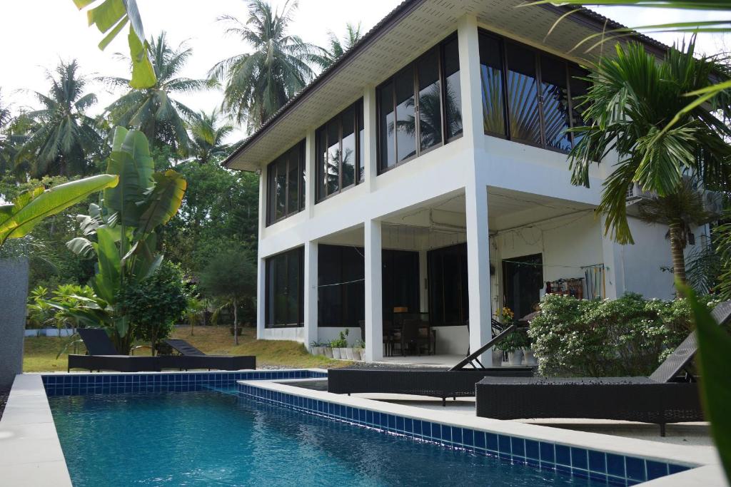 a house with a swimming pool in front of it at Twin Villas Apartment with Swimming Pool in Wok Tum