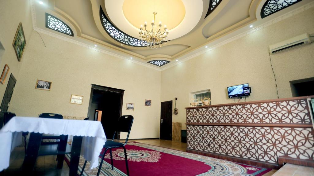 a dining room with a table and a chandelier at Yulduz Hotel in Khiva