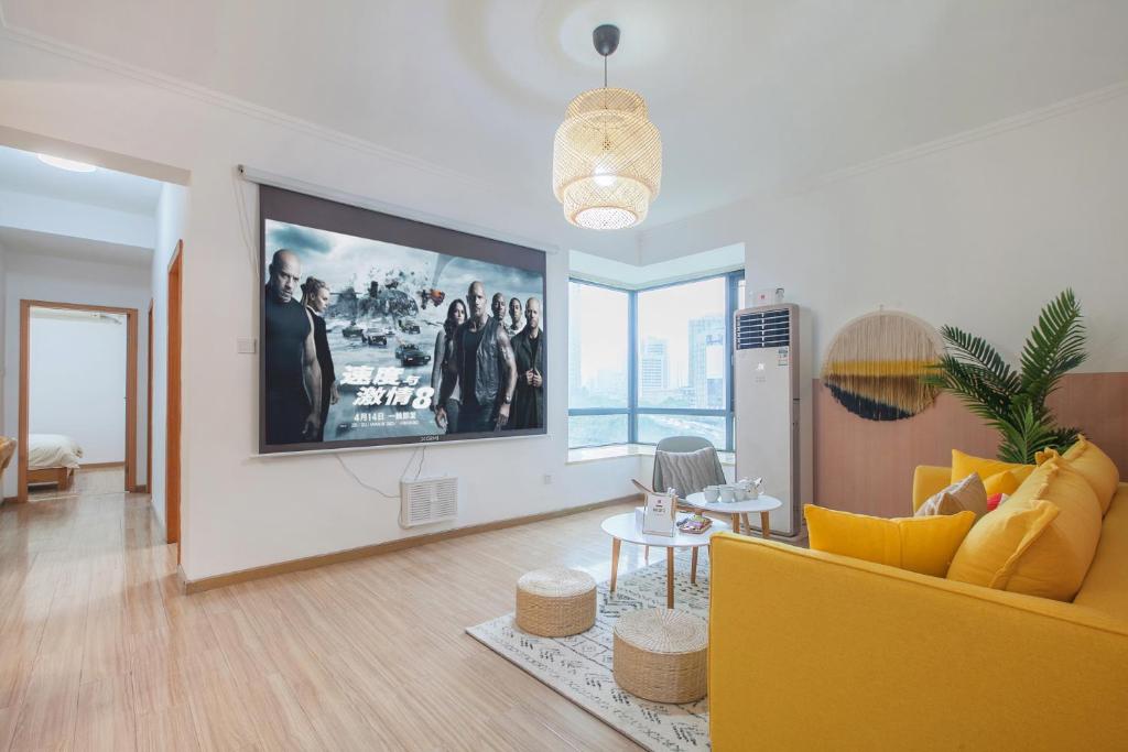 a living room with a yellow couch and a tv at [Roader] Wuhan Jiang'an District · Sanyang Road in Wuhan