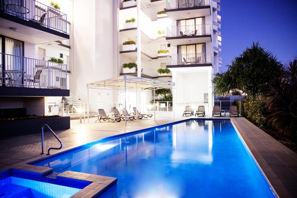 a swimming pool in front of a building at Ocean Views Resort Caloundra in Caloundra