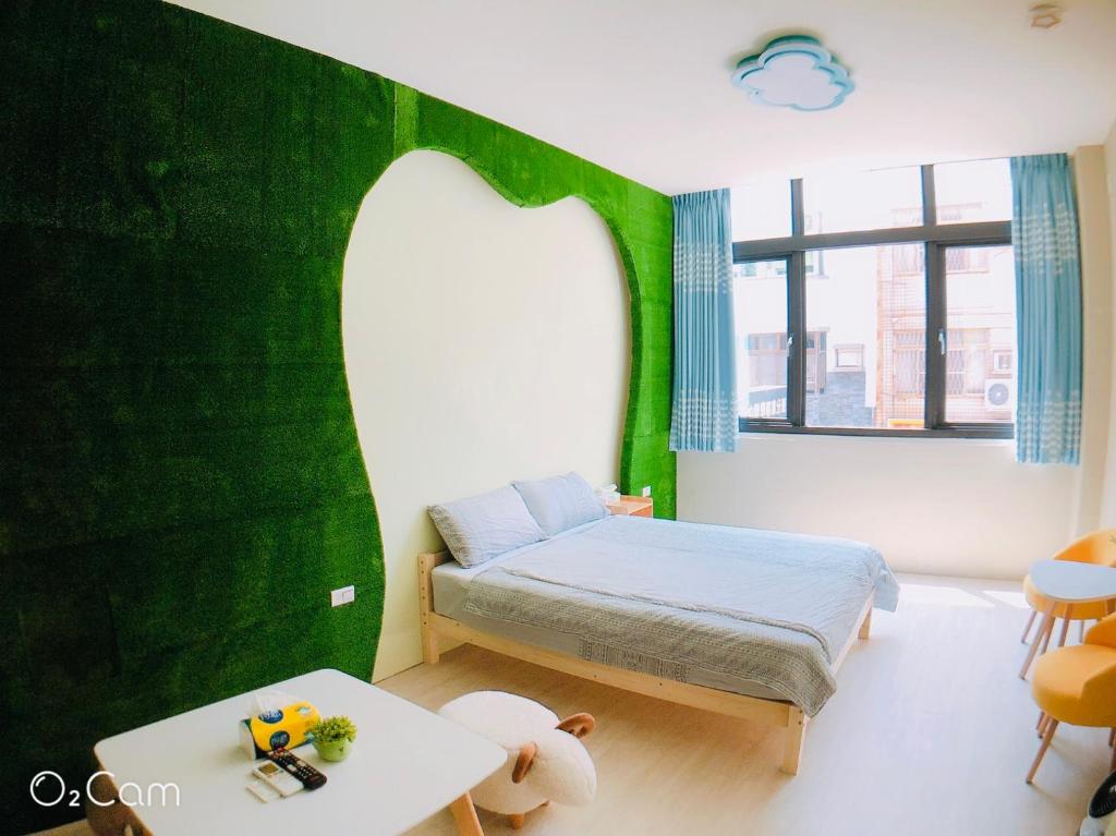 Kleines Zimmer mit einem Bett und einem Tisch in der Unterkunft Greenonly Homestay in Tainan