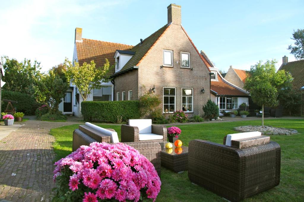 een tuin met stoelen en bloemen voor een huis bij Wadanders in Hollum