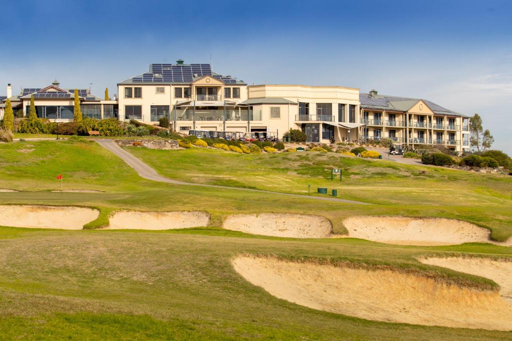 a grassy hillside with a large building at McCracken Country Club in Victor Harbor