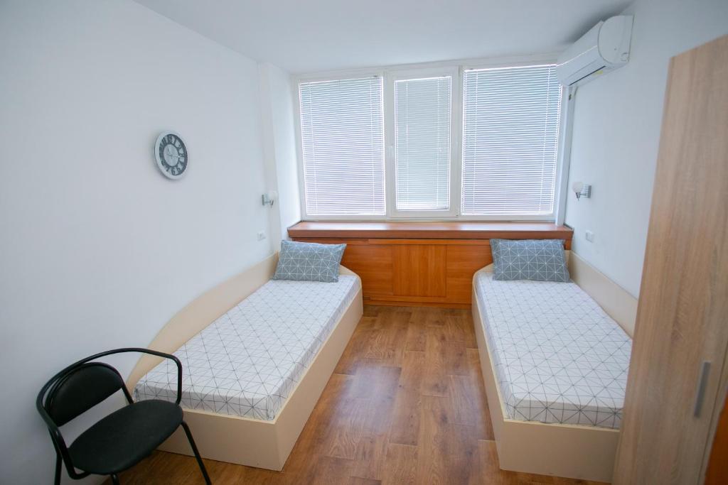 a room with two beds and a chair in it at Рачо Ковача in Gabrovo