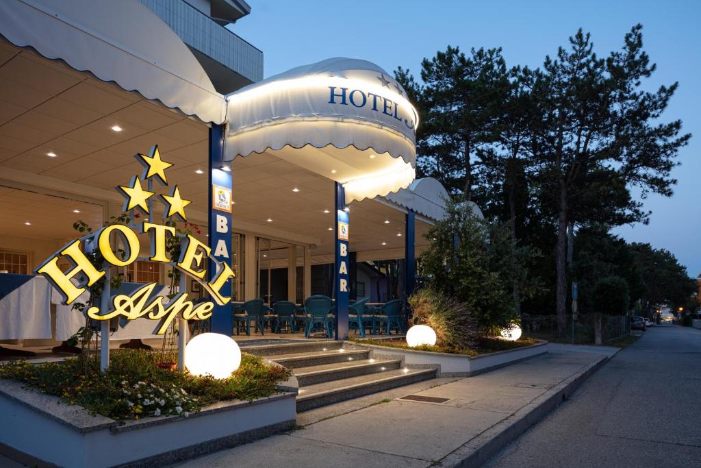 un bâtiment d'hôtel avec un panneau vivant devant lui dans l'établissement Hotel Villa Aspe, à Bibione