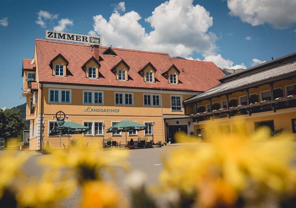 a large yellow building with a red roof at Landgasthof Gietl in Kammern im Liesingtal