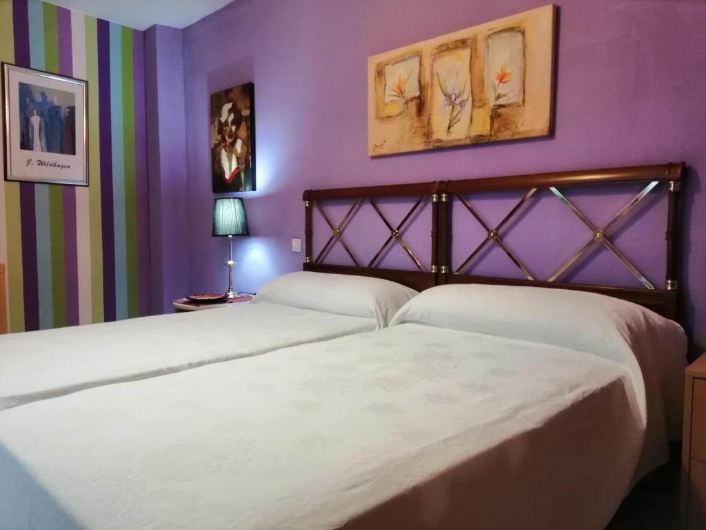 サラゴサにあるApartamento Teatro del Mercadoの紫の壁のベッドルーム1室(ベッド2台付)