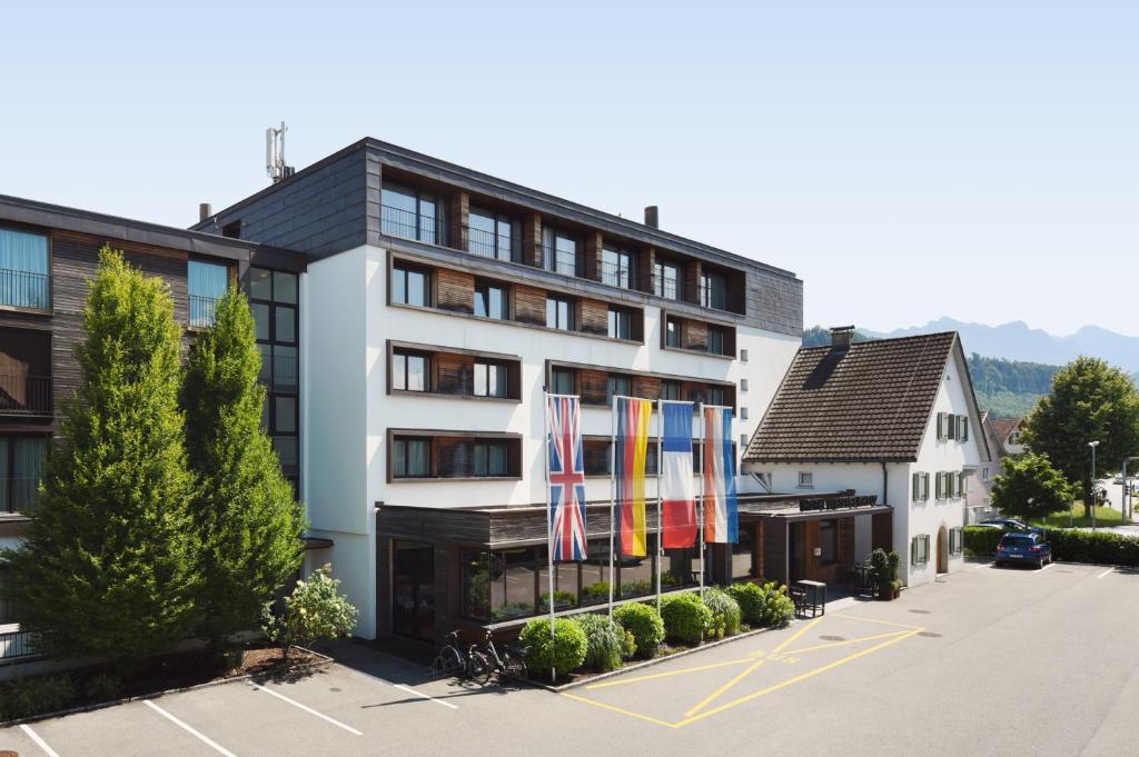 um hotel com bandeiras em frente a um edifício em Hotel Weisses Kreuz em Feldkirch