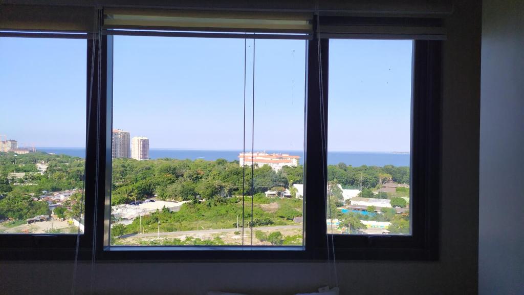 three windows in a room with a view of a city at Island Living at One Manchester Place in Mactan