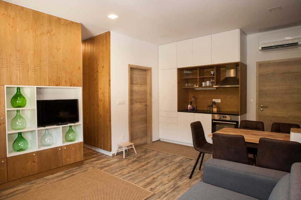 a living room with a dining room table and a kitchen at Family fun Pohorje in Ruše