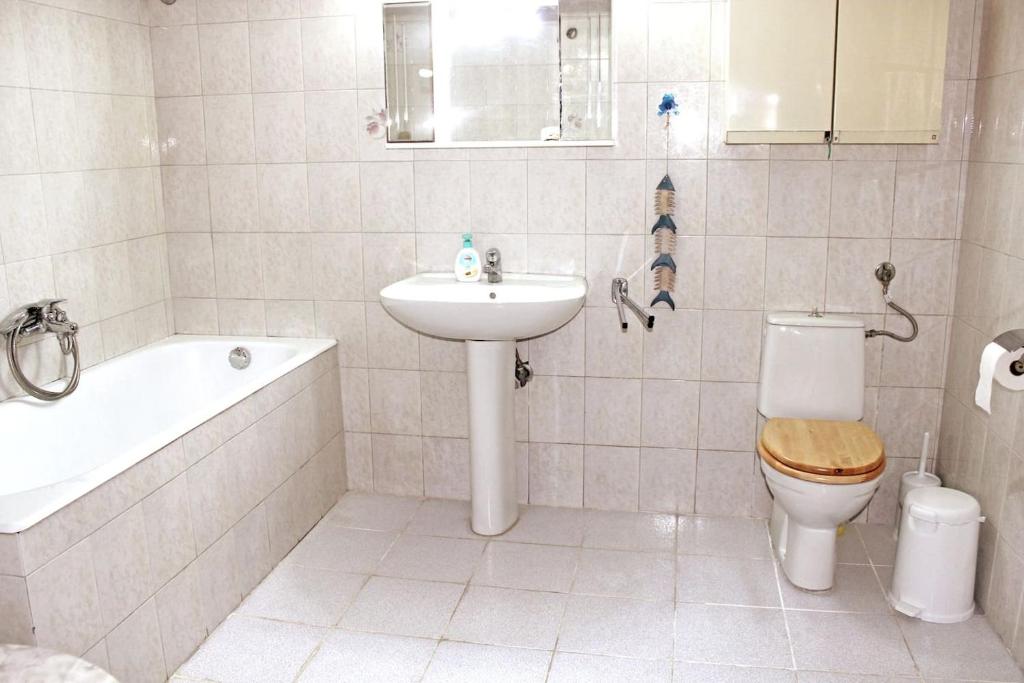 a bathroom with a sink and a toilet and a bath tub at Victoria's Apartment in Thessaloniki
