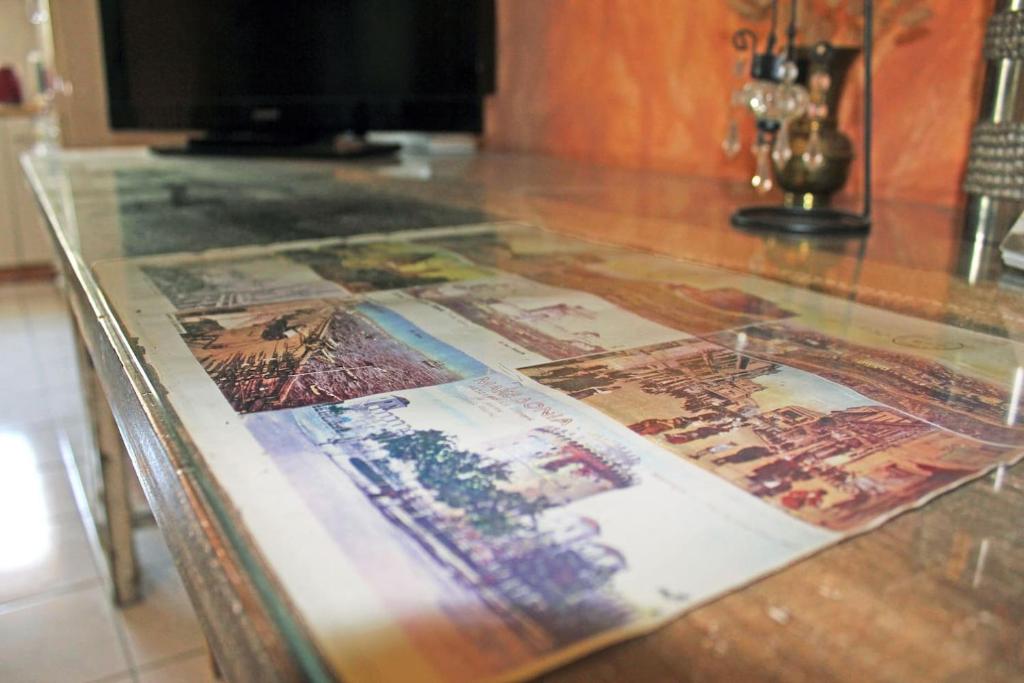 a glass table with many pictures on it at Victoria's Apartment in Thessaloniki