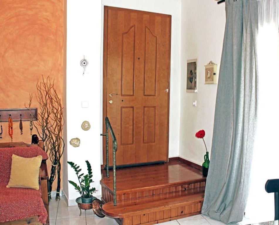 a room with a wooden door and a red couch at Victoria's Apartment in Thessaloniki