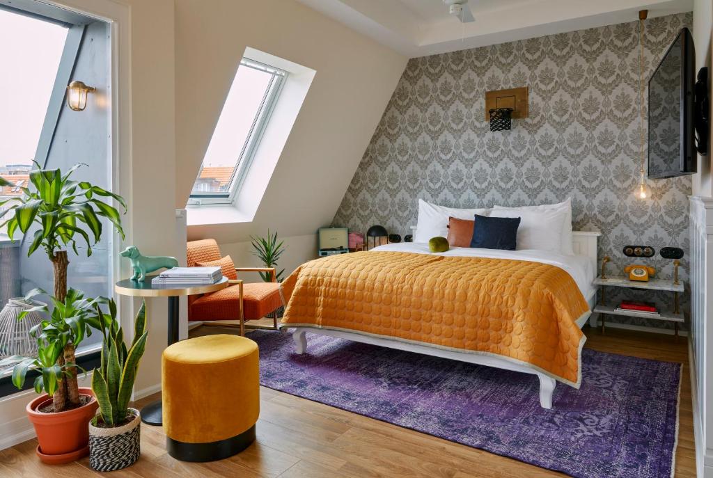 ein Schlafzimmer mit einem orangenen Bett und einem lila Teppich in der Unterkunft Max Brown Hotel Ku'damm, part of Sircle Collection in Berlin