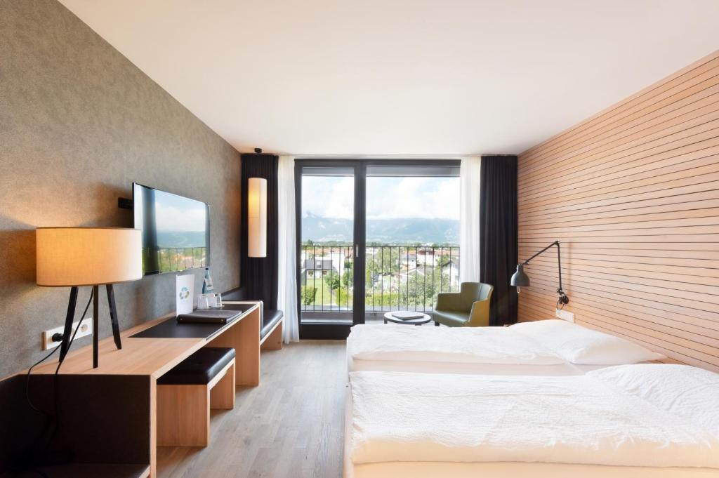 um quarto de hotel com duas camas e uma grande janela em Hotel Weisses Kreuz em Feldkirch